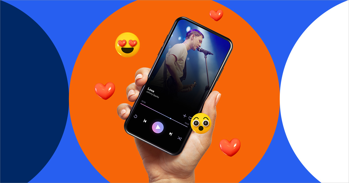 A smartphone held in someone's hand displaying a singer on stage and surrounded by emojis to indicate reactions on social media
